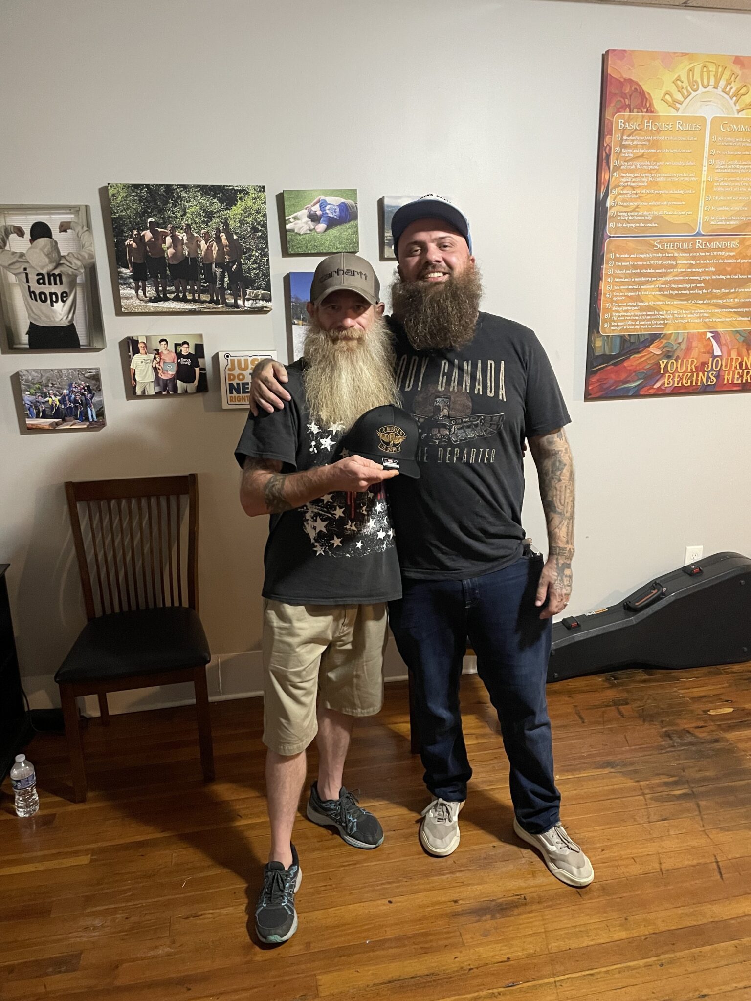 Two friends smiling with beards indoors.