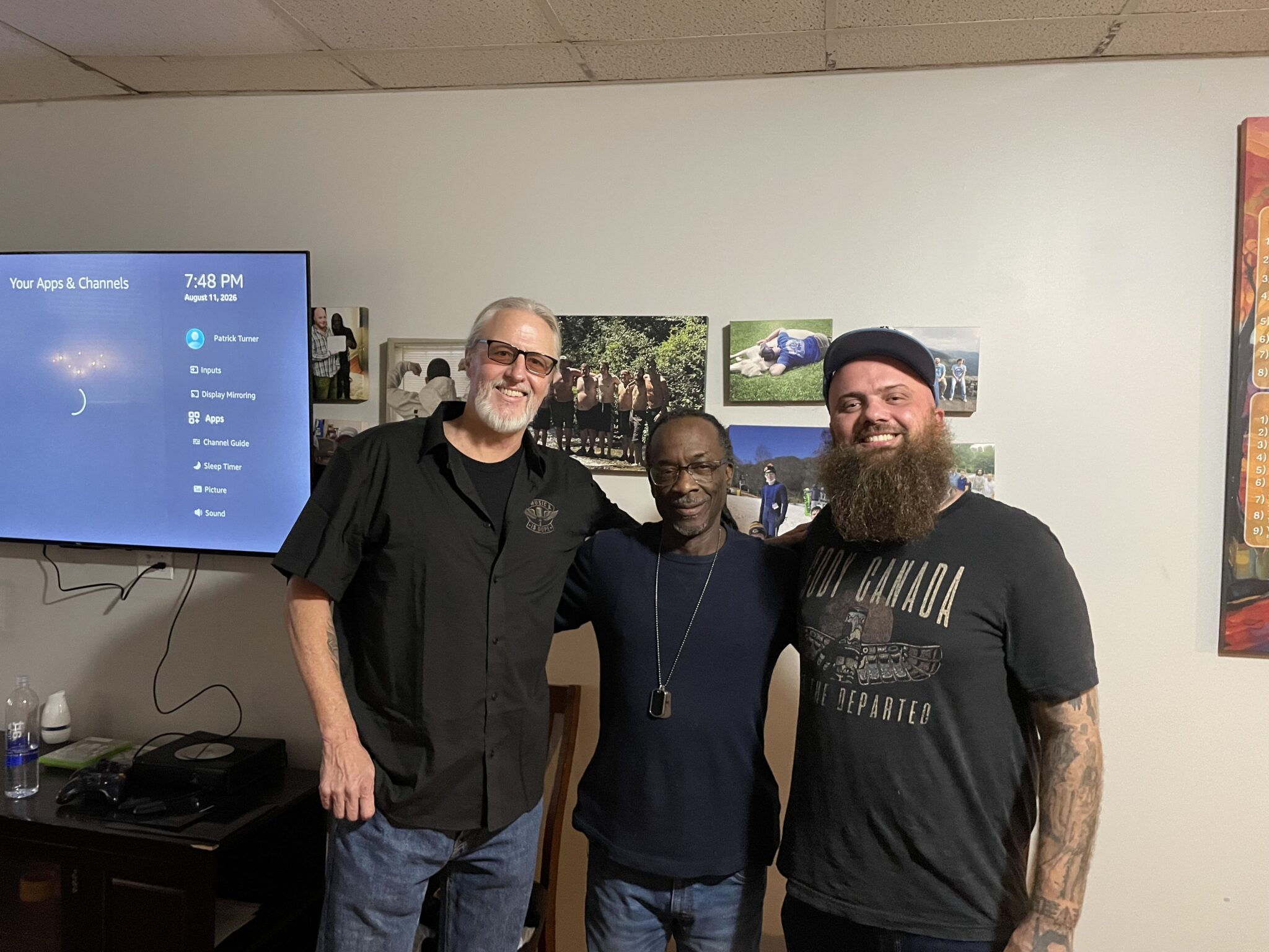 Three men posing together in a casual setting.